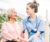 young nurse wearing blue scrubs comforts elderly patient