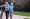 Elderly couple walk along side their bike on a paved biking trail