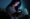 Woman stares at her phone in a dark room