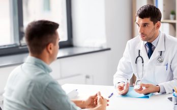 Physicians and patient are seated discussing care plans