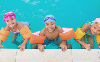photo of three children smiling in the pool