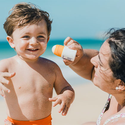 mother putting sunscreen on child