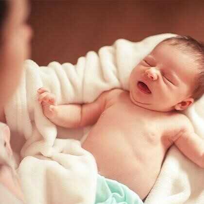 Mom admires newborn baby in her arms