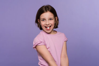 Young girl happily shows her chewable supplement on her tongue before taking it