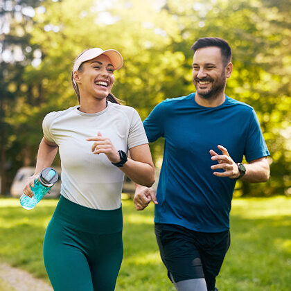 A couple smiling while running outside