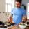 Young man meal preps for the week, dividing food into multiple containers