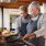 Elderly couple works to cook dinner together in their kitchen