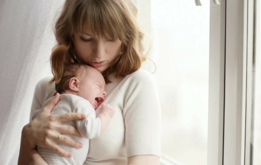 mother holding crying baby
