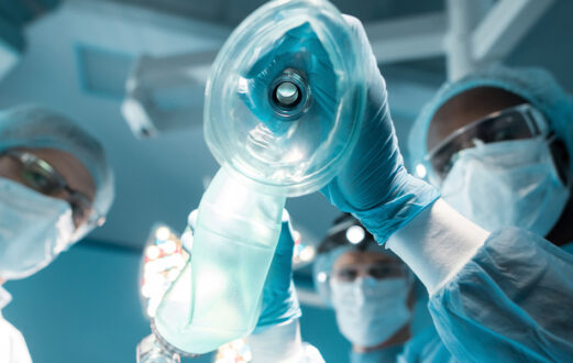 Surgeons get ready to place an anesthesia mask over a patient in an operating room