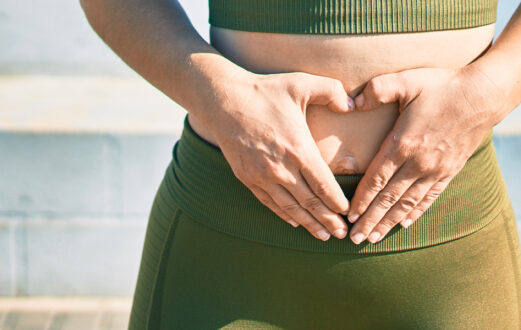 Woman holding a smiley face block in front of her stomach