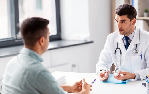 Physicians and patient are seated discussing care plans