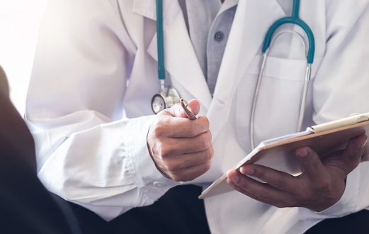 Medical Provider takes notes while speaking with a patient