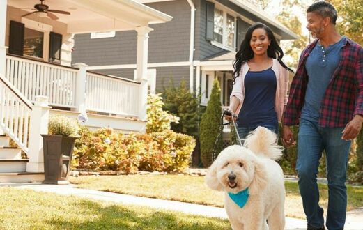 A couple stays active by walking a dog.