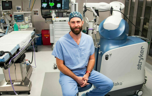 Dr Williams sits in an operating room with the Mako SmartRobotics technology for joint surgery.