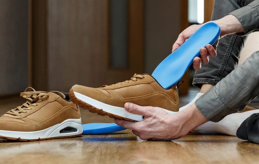 Individual inserts a custom orthotic into their shoe