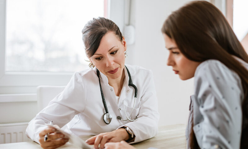 Doctor explaining results to woman looking at papers