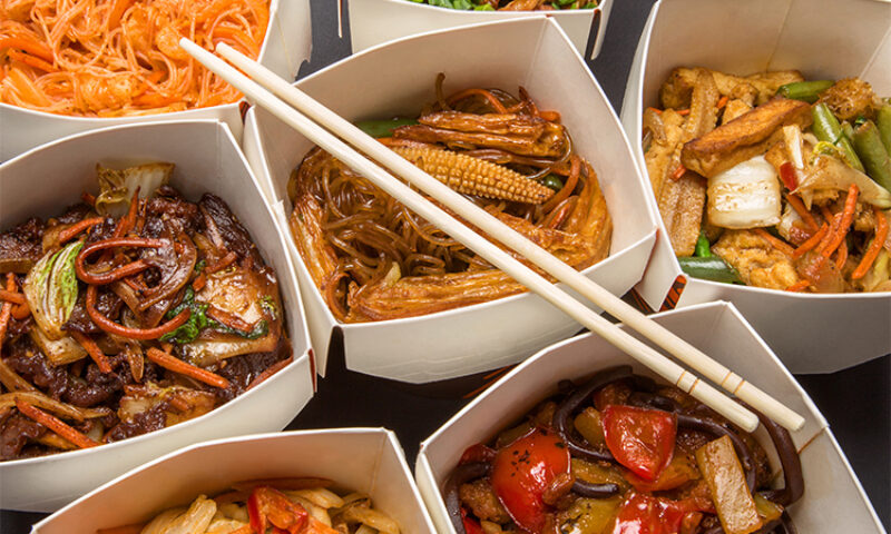 Multiple plates of food with chopsticks