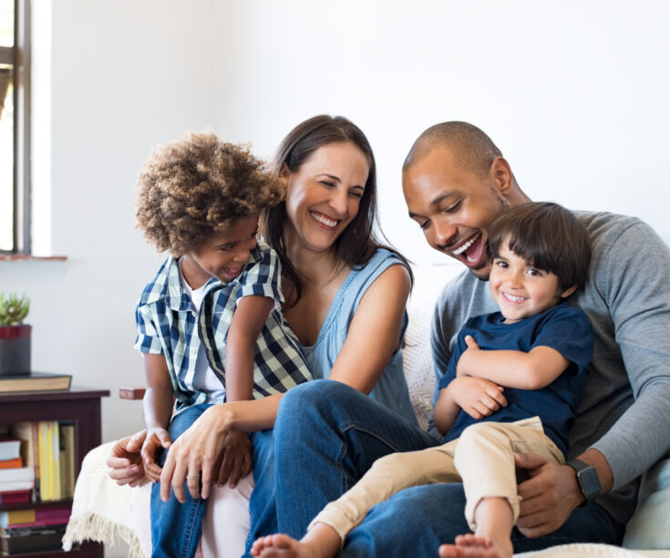 family smiling on the couch at home
