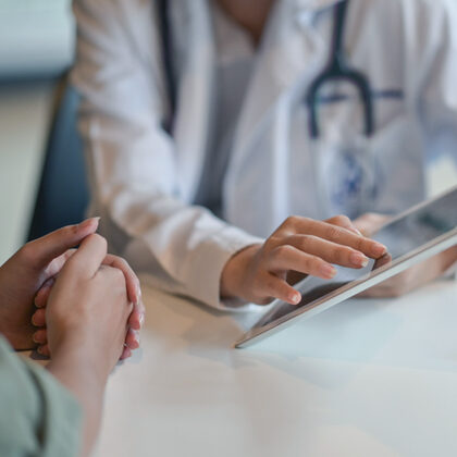 Doctor wearing a white lab coat explains acid reflux treatment options to a patient