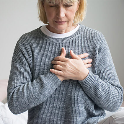 woman holding her chest with both hands