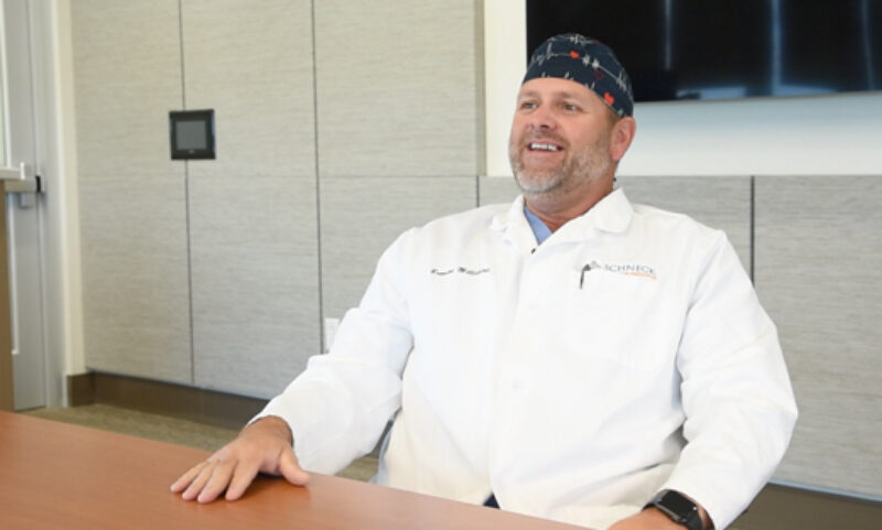 Dr. Millick laughs while sitting in classroom
