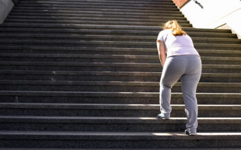 Woman taking rest while walking up stairs