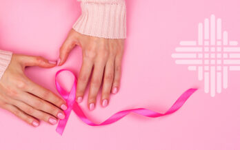 Hands folding a pink ribbon
