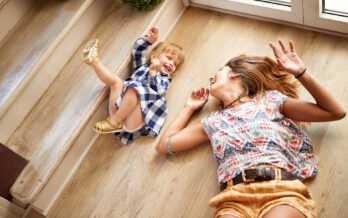 Mother and daughter lying on floor and laughing