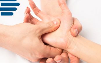 A massage therapists holds a patient's hand and performs a massage on the palm