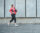 Woman wearing work-out clothes running on brick street