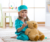 A young girl sits on a rug in her bedroom playing dress up as a doctor.