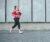 Woman wearing work-out clothes running on brick street