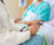 Close up of doctor sitting next to patient in hospital bed.  Doctor has stethoscope in his hands