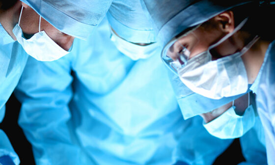 Close up of surgeons looking at patient in surgery suite
