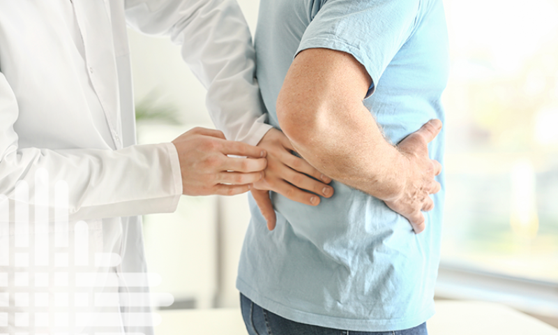 A doctor examines the sides of a male patient, feeling for any issues.