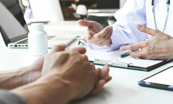patient and doctor sit across from each other at a desk