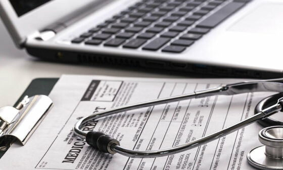 stethoscope rests on clipboard with medical forms