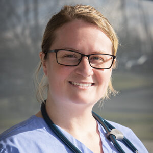 Close up of Elizabeth LeQuay outside of the Schneck Emergency Room. She is wearing blue scrubs and a stethoscope