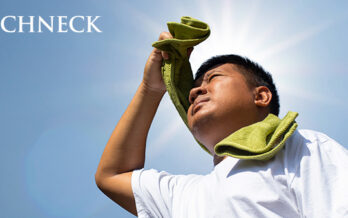 boy with towel around his neck uses his hand to block sunlight
