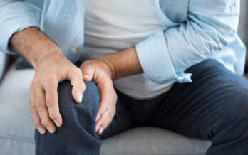 Elderly man holding his knee