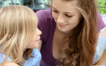 Teen girl playing with young children