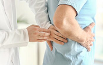 Doctor placing hands on patient's back as he shows where his kidney pain is located