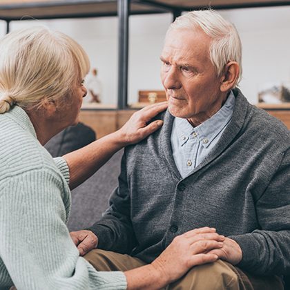 woman speaking to man with her hand on his