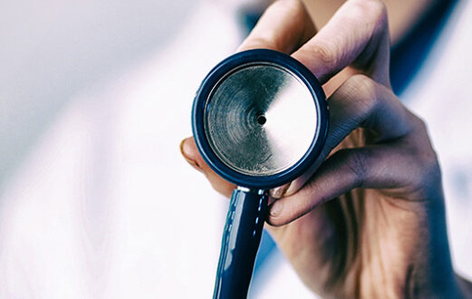 close up of hand holding stethoscope toward camera
