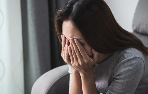 Woman sits with her head in her hands