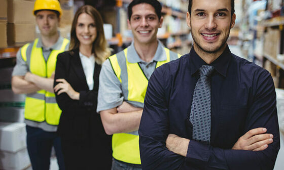 Two men in yellow vests, a man in a tie, and a woman in a suit in a line
