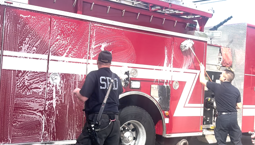 photo of firemen washing their truck