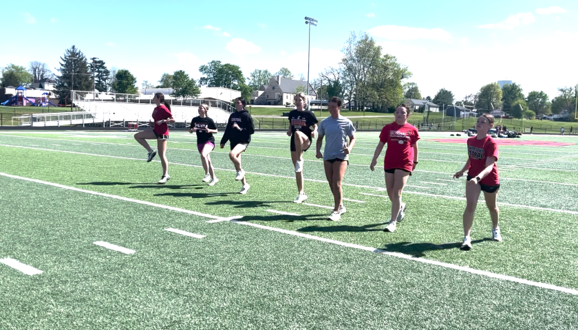 photo of group of people warming up on football field