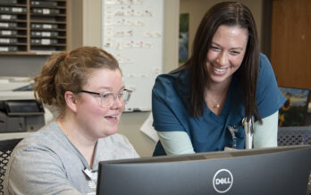 Two women talking and smiling at the computer