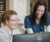 Two women talking and smiling at the computer